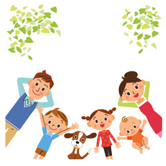 新緑の下でリラックスして寝そべる家族