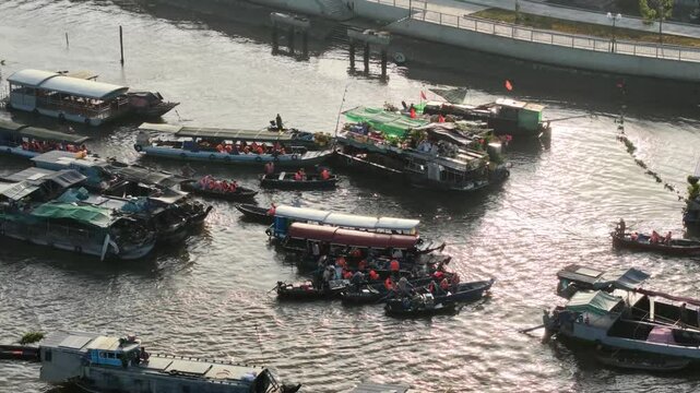 Aerial drone footage captures a bustling floating market in Vietnam, where numerous boats gather to trade goods, creating a vibrant scene on the river.