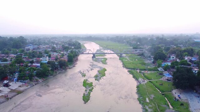 Polluted and dirty Mahananda River with wastewater open drainage surrounding slum neighborhoods, Siliguri, Drone shot