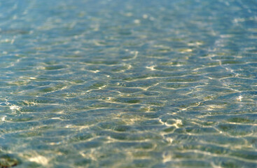 Wave close up with reflection of sunlight and rippled on the ocean water surface, Abstract blur wave on the sea, clear water close-up with Colorful Background and copy space.