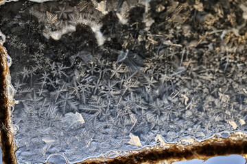 ice pattern on winter glass, abstract background on a cold sunny day