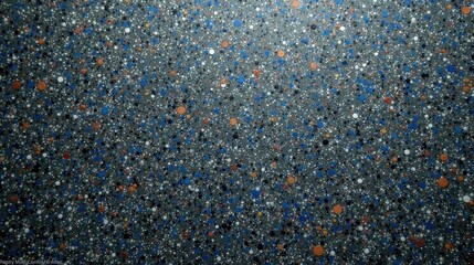 Abstract speckled surface texture with a multitude of small and large dots in varying shades of blue, orange, white, and black on a dark gray background