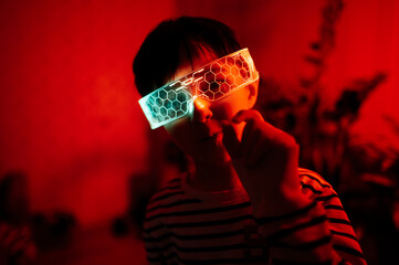 Child wearing futuristic smart glasses in a red-lit room