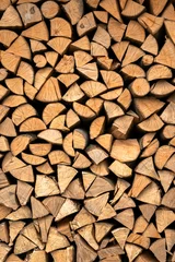 Selbstklebende Fototapeten Stacked split hardwood firewood arranged in a row for drying. Close-up of firewood texture © Ivan Kmit
