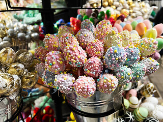 Bucket of vibrant and colorful candy-like decorations at a festive market
