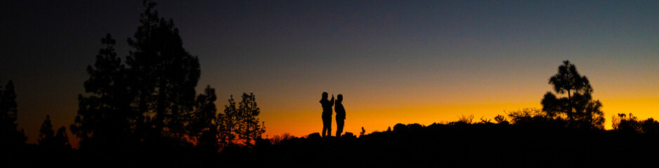 Fototapeta premium peope taking a smartphone picture in a sundown panorama