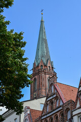 Obraz premium A walking tour through the historic old town of the Hanseatic city of Lüneburg, with its traditional brick houses under a blue summer sky, Lower Saxony, Germany