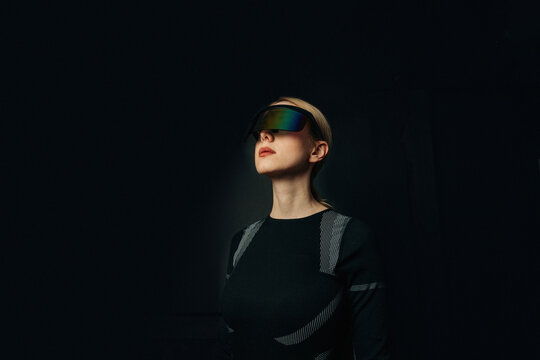 Person wearing VR glasses in a dark setting with a futuristic theme