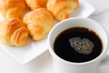 焼き立てでサクサクの食感のクロワッサンと、淹れたてのコーヒーの朝食
