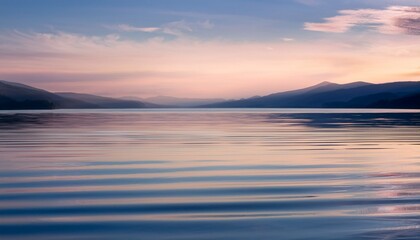 Obraz premium Macro calm lake surface: small ripples, distant mountains, soft cool color. Serene nature vista