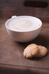 Cappuccino on dark wooden background. Soft focus. Close up.	