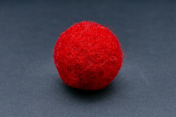 red felt ball on a gray background