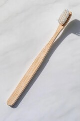 Naklejka premium Natural wooden toothbrush with soft bristles resting on smooth s