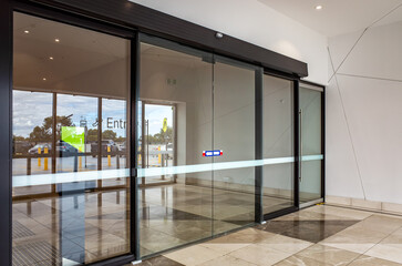 Modern automatic sliding glass doors at the entrance of a commercial building or shopping center,...