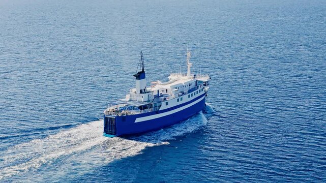 Passenger ferry cruising in high speed the Aegean deep blue sea, Drone camera follows ship