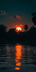Obraz premium Tropical Paradise at Sunset Palm Trees Silhouetted Against Vibrant Orange Sky with Water Reflection