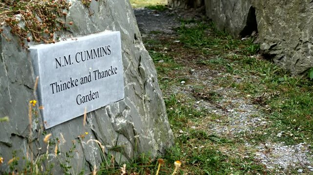 A stone plaque marks the N.M. Cummins "Thincke and Thancke" Garden in Ireland, a historical site commemorating Irish heritage and reflection.