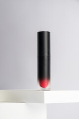 Mockup of black blank thin tube - mascara, lip gloss, gel, eyeliner, oil, etc. Cosmetic package with stylish props on white background. 
