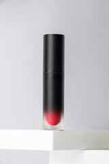 Mockup of black blank thin tube - mascara, lip gloss, gel, eyeliner, oil, etc. Cosmetic package with stylish props on white background. 