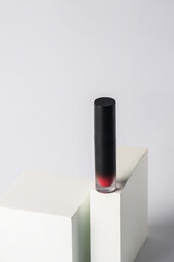 Mockup of black blank thin tube - mascara, lip gloss, gel, eyeliner, oil, etc. Cosmetic package with stylish props on white background.