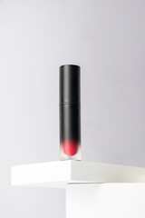 Mockup of black blank thin tube - mascara, lip gloss, gel, eyeliner, oil, etc. Cosmetic package with stylish props on white background.