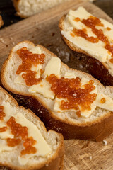a soft loaf of wheat flour with butter and red salmon caviar