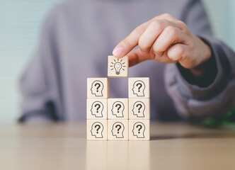 Creative thinking and problem solving concept. Hand stacking wooden blocks with question marks,...