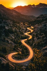 Scenic mountain highway with golden sunset and winding curves.
