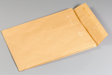 Open light brown paper mailing packing bag on gray background