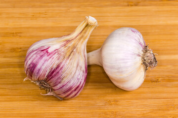 Bulbs of purple striped garlic on a wooden surface