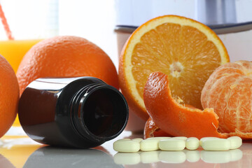 Ripe oranges and vitamin c pills, on white background