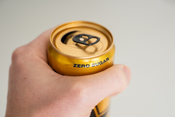 hand holding a zero sugar soda can.