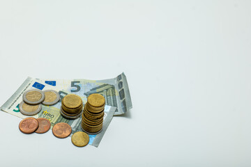 Five euro banknotes, cash paper money and coins isolated on white background