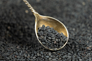 Natural black sesame grains in a spoon macro close-up