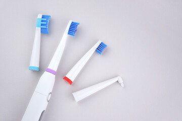 Modern electric ultrasonic toothbrush with rechargeable battery on a gray surface.