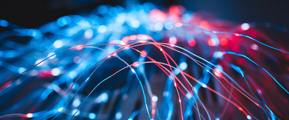 Close-up view of illuminated fiber optic cables glowing in blue and red, representing high-speed data transmission, digital communication, and modern technological advancements.