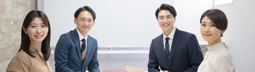 Several male and female businessmen in a meeting Banner in front of the camera's eye