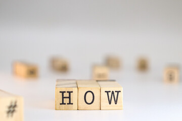 The word how written on wooden cubes on a white background with space for text