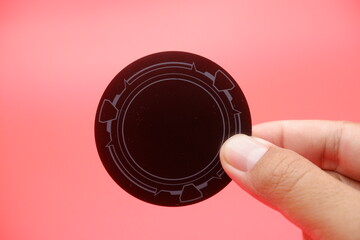 Hand Holding Aluminum Heatsink Pad Against Red Background