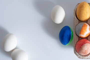 Happy Easter. Colorfully painted Easter eggs and white eggs on the table