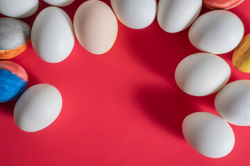 Colorful Easter eggs arranged on a red background with copy space for text.