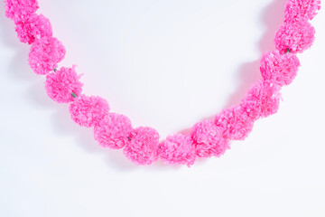 Obraz premium Bright pink artificial flower garland on a white background.
