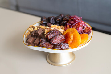 A plate of mixed dried fruits and dates. Coffee snacks.