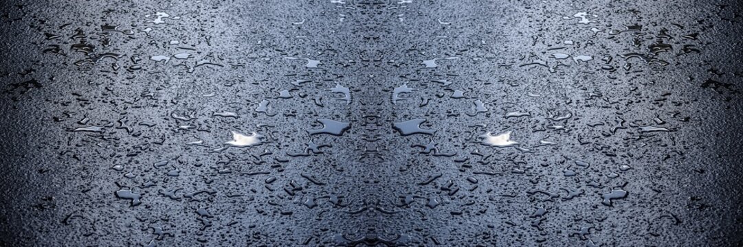 Des petites flaques d'eau sur le bitume, avec effet sym&eacute;trique