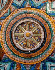A macro shot of a colorful tile mosaic on a historic building, showcasing intricate symmetrical patterns and vibrant colors, highlighting the craftsmanship and historical artistry.