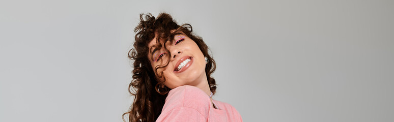 Young stylish woman radiating emotions in a trendy outfit against a light background
