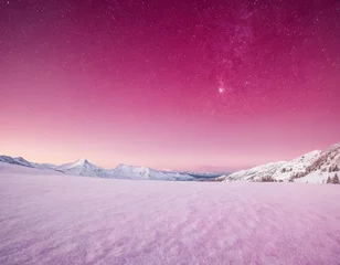 Selbstklebende Fototapeten A breathtaking winter landscape at twilight showcasing snow-covered mountains under a starry pink sky. © Viktor