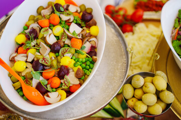 A large served table with salads, vegetables and barbecue. a variety of treats and snacks for the holiday. catering for a banquet.
