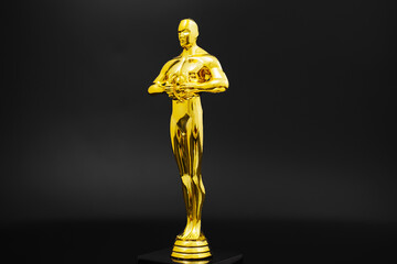 The golden statuette of the film award on a black background. awarding for achievements and...