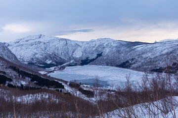 Fototapeta premium A beautiful mountain landscape with snow over the fjords in Norway. Arctic nature in Scandinavia during winter season.